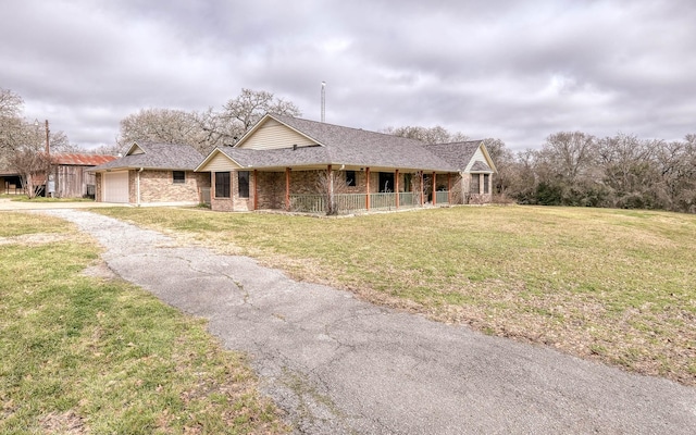 view of front facade with a garage, a front yard, aphalt driveway, and brick siding