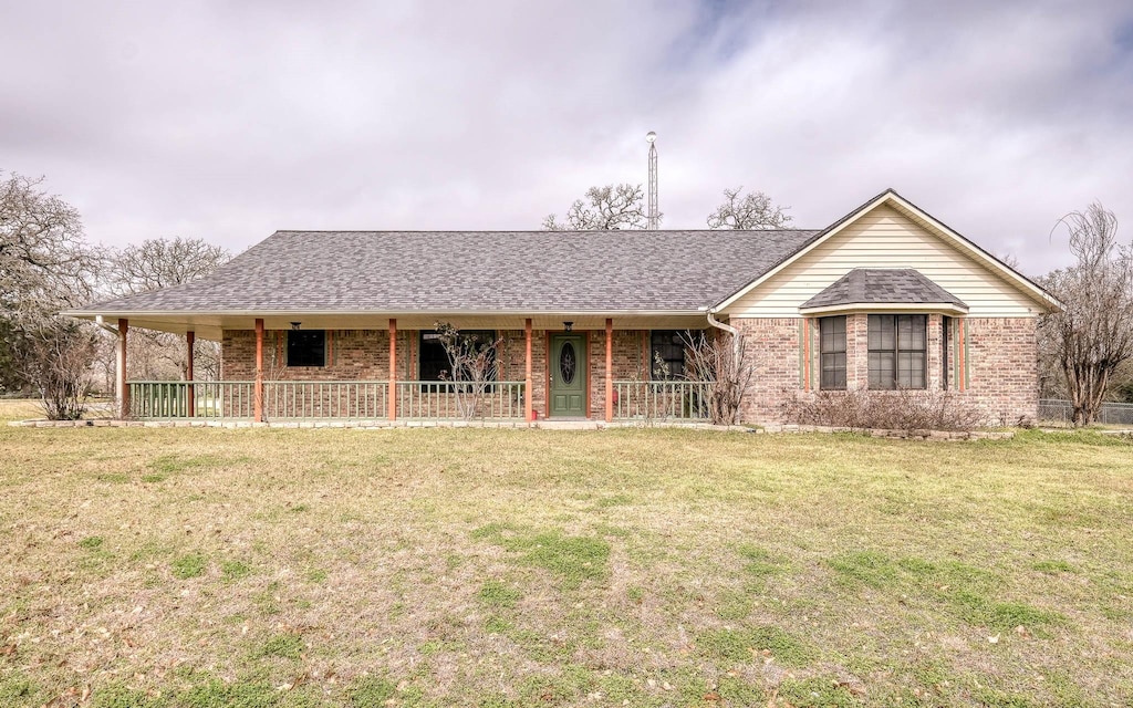 2101 N Berlin Rd, Brenham, TX 77833 - ranch-style home featuring covered porch, brick siding, a front yard, and a shingled roof