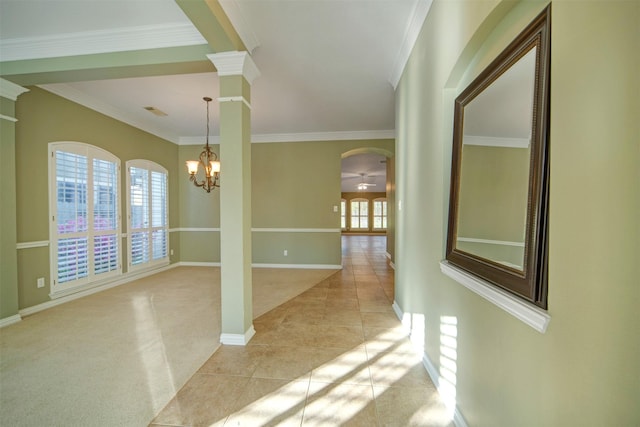 interior space with light carpet, decorative columns, light tile patterned floors, and ornamental molding