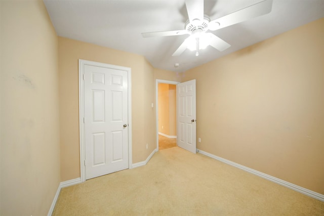 unfurnished bedroom featuring ceiling fan, baseboards, and light carpet