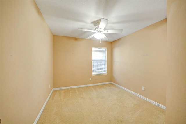 empty room with baseboards, light carpet, and a ceiling fan