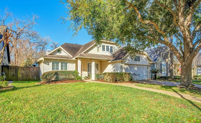 view of front of home featuring a front yard, an attached garage, fence, and driveway