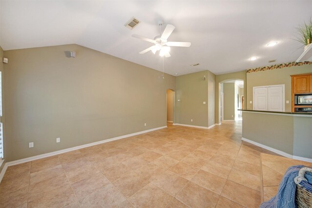 unfurnished living room featuring visible vents, baseboards, lofted ceiling, arched walkways, and a ceiling fan