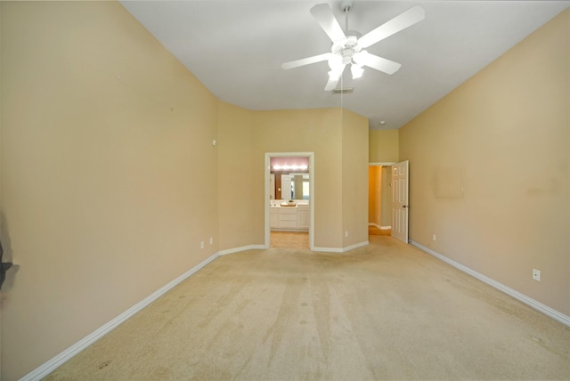 unfurnished bedroom featuring visible vents, baseboards, ceiling fan, ensuite bathroom, and light colored carpet