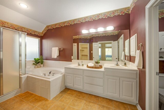 bathroom featuring a wealth of natural light, a stall shower, a sink, lofted ceiling, and a bath