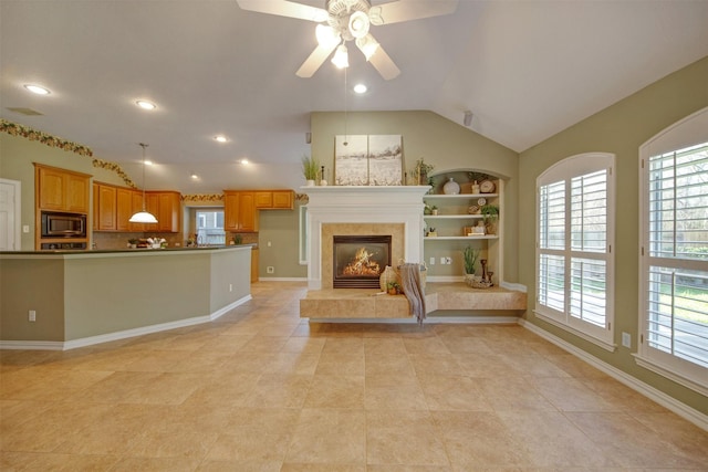 unfurnished living room with recessed lighting, lofted ceiling, a ceiling fan, and a tiled fireplace