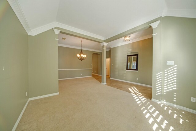 carpeted empty room with decorative columns, baseboards, a chandelier, and crown molding