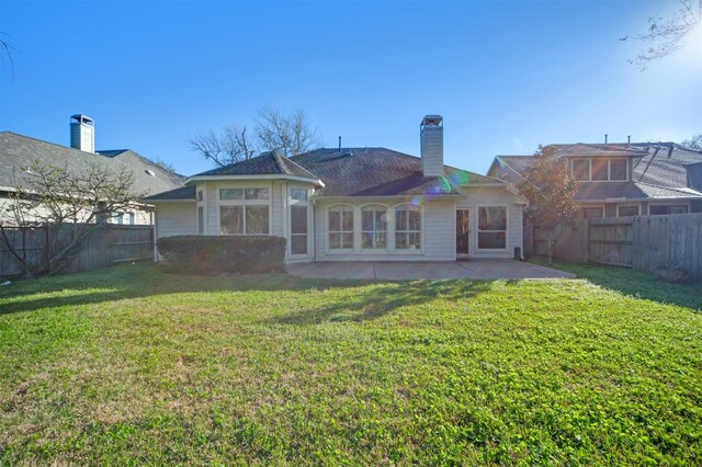 back of property featuring a yard, a patio, and a fenced backyard