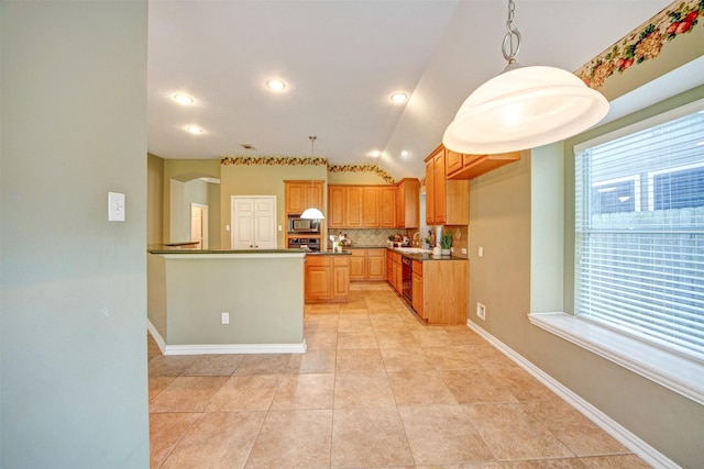 kitchen with dark countertops, stainless steel microwave, baseboards, vaulted ceiling, and decorative backsplash