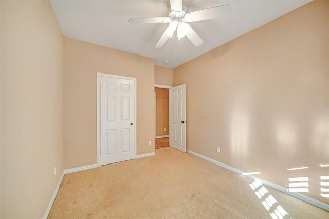 unfurnished bedroom with baseboards, carpet floors, and a ceiling fan