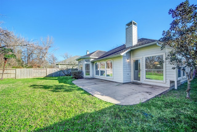 rear view of property with a patio, fence, a lawn, and a chimney