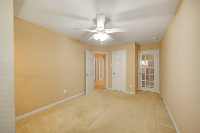 unfurnished room featuring baseboards, carpet, and ceiling fan