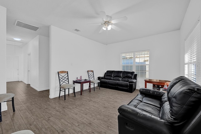 living room with attic access, wood finished floors, visible vents, and ceiling fan