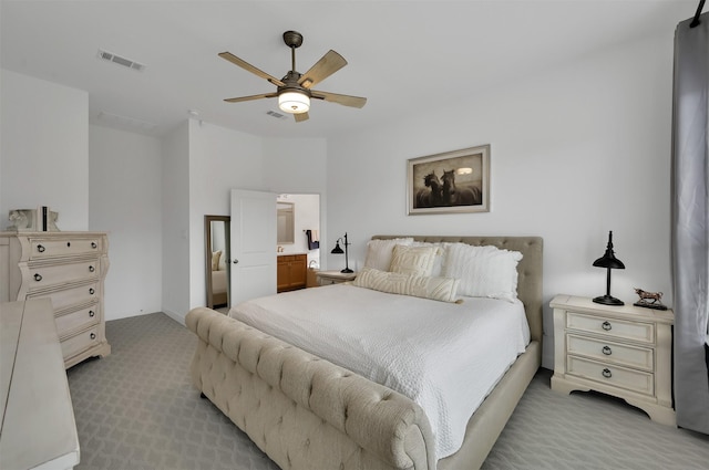 bedroom featuring light carpet, ceiling fan, visible vents, and ensuite bathroom