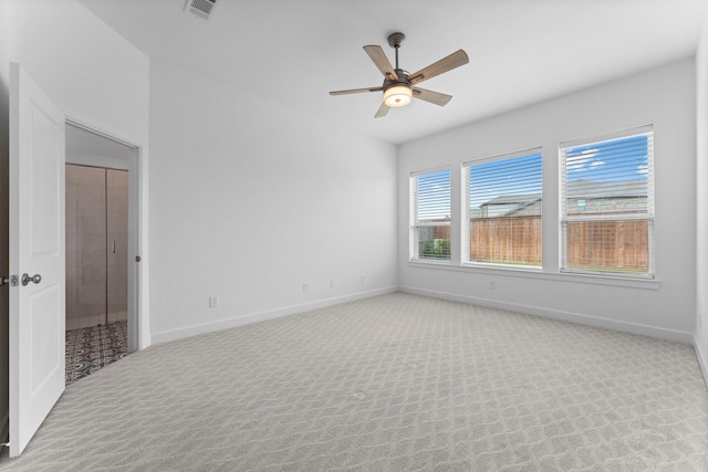 carpeted empty room with ceiling fan, visible vents, and baseboards