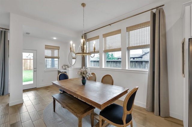 dining space with baseboards, light wood finished floors, visible vents, and an inviting chandelier