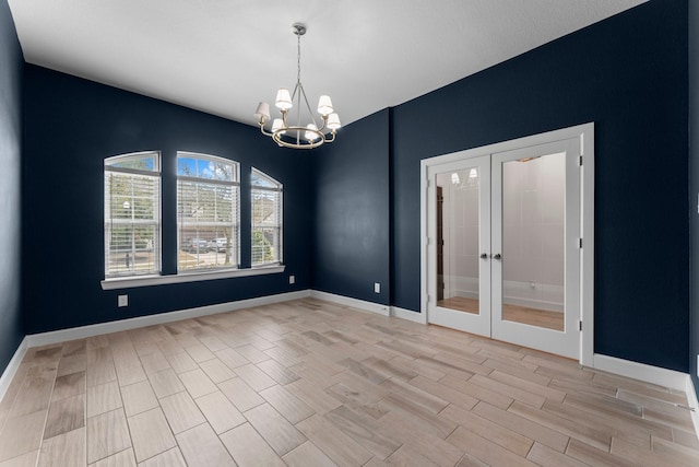 empty room featuring light wood-style floors, french doors, baseboards, and an inviting chandelier