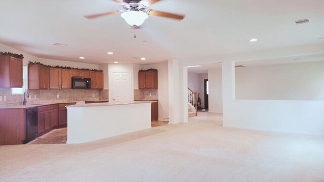 kitchen featuring visible vents, light colored carpet, a sink, black appliances, and backsplash