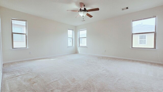 unfurnished room featuring light colored carpet, visible vents, ceiling fan, and baseboards