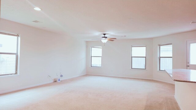 spare room with a ceiling fan, recessed lighting, light colored carpet, and baseboards