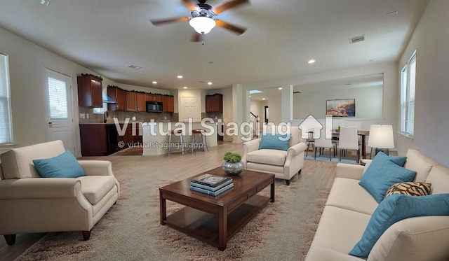 living room featuring a ceiling fan, light wood-style floors, visible vents, and recessed lighting