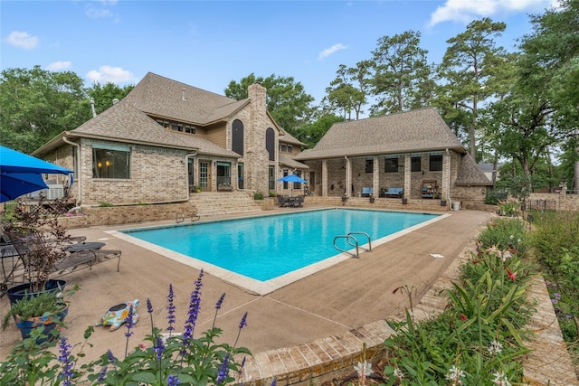 pool featuring a storage structure, an outbuilding, and a patio area