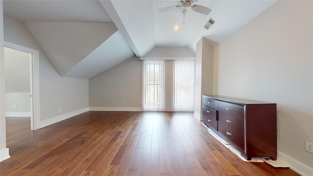 bonus room featuring vaulted ceiling, dark wood-style flooring, visible vents, and baseboards