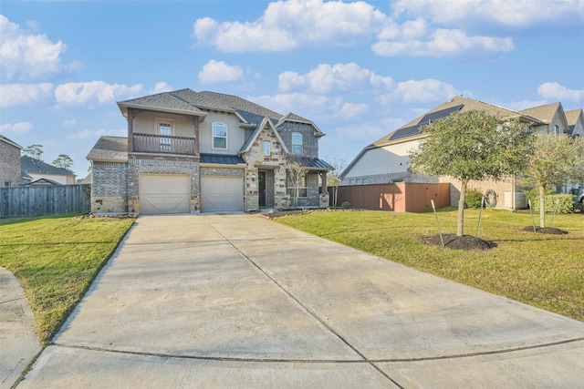 view of front facade featuring an attached garage, a balcony, fence, and a front lawn