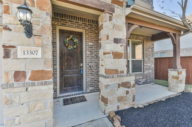 entrance to property featuring stone siding and brick siding