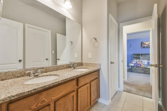 full bath featuring double vanity, baseboards, a sink, and tile patterned floors