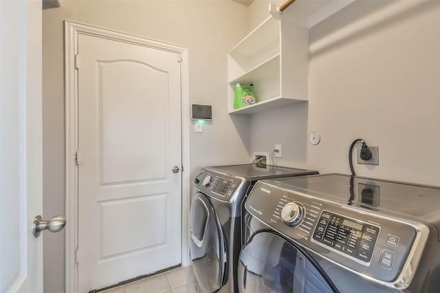 laundry area featuring laundry area, light tile patterned floors, and washing machine and clothes dryer