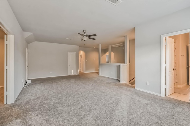 unfurnished living room with arched walkways, carpet flooring, ceiling fan, and visible vents