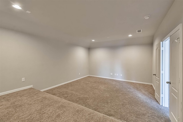 carpeted empty room featuring baseboards, visible vents, and recessed lighting