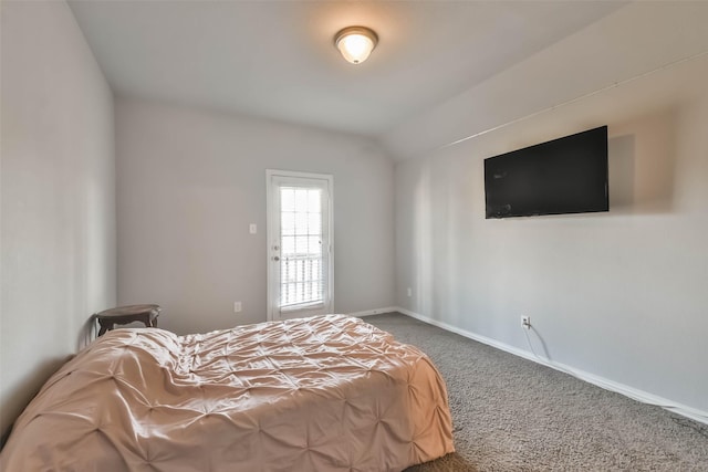 carpeted bedroom with lofted ceiling and baseboards