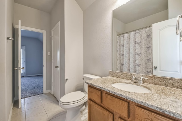 bathroom with toilet, vanity, and tile patterned floors