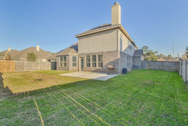 rear view of house with brick siding, a yard, a chimney, a patio, and a fenced backyard