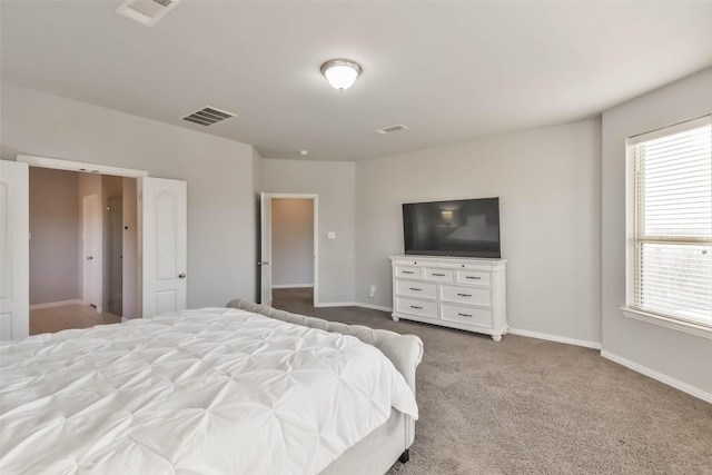 carpeted bedroom with baseboards, multiple windows, and visible vents