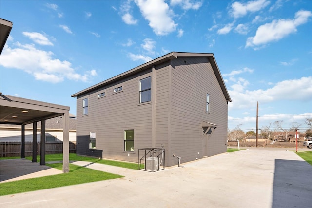 view of property exterior with a patio and fence