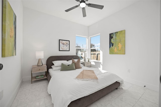 bedroom with marble finish floor, a ceiling fan, and baseboards