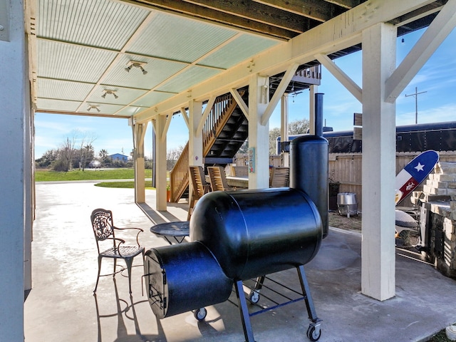 view of patio featuring stairway and fence