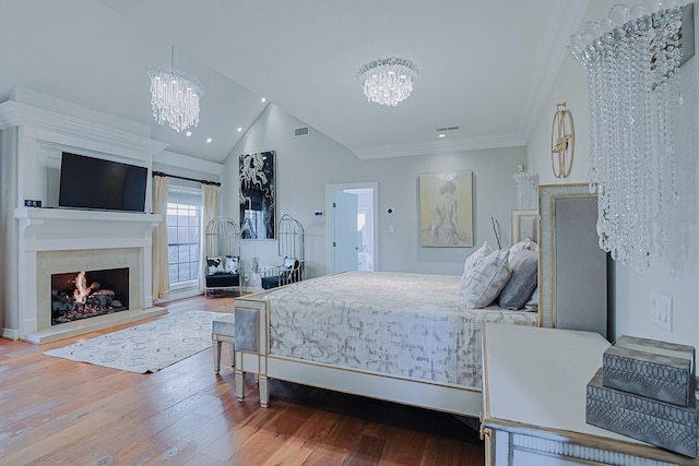 bedroom with a lit fireplace, visible vents, a notable chandelier, and wood finished floors