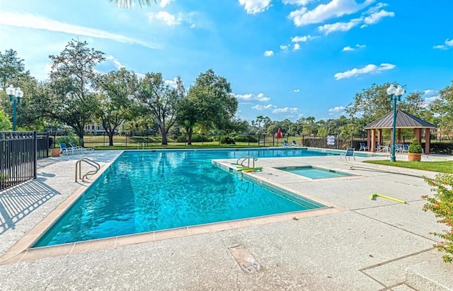 pool with a gazebo, a patio, and fence