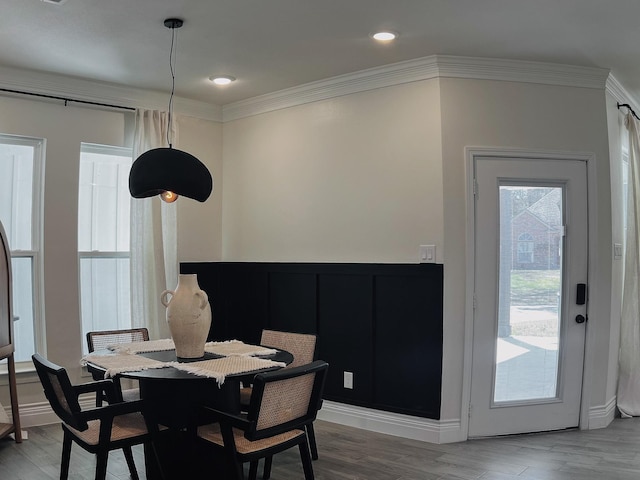 dining room featuring light wood-style flooring, ornamental molding, baseboards, and recessed lighting