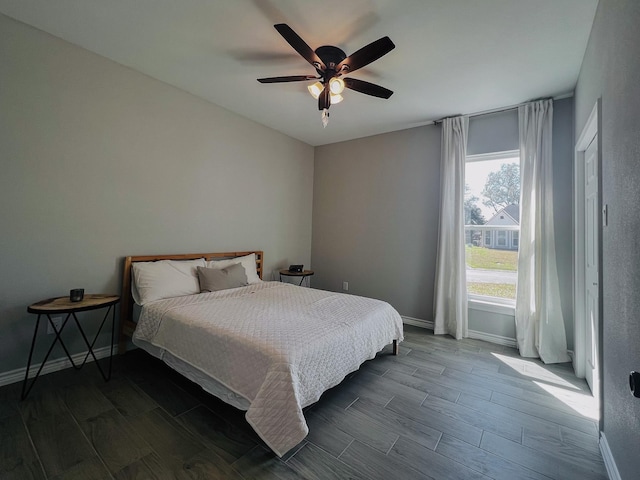 bedroom with ceiling fan, baseboards, and wood finish floors