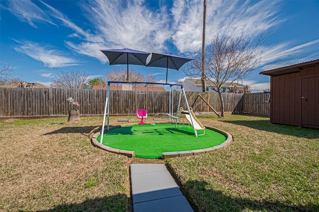 view of jungle gym featuring a fenced backyard, a yard, and an outdoor structure