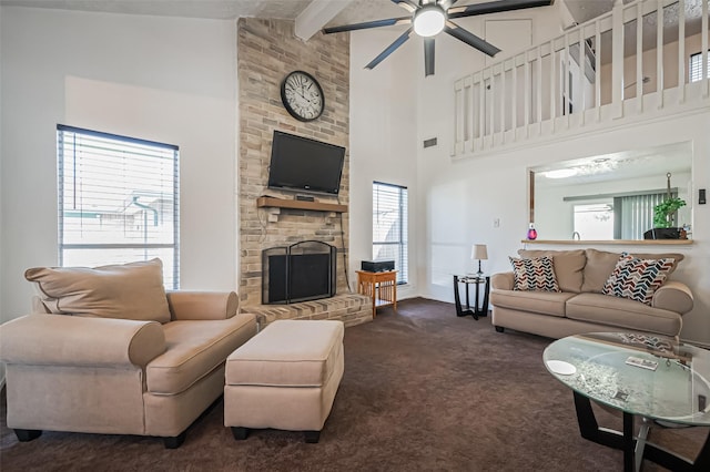 living room with carpet, a towering ceiling, a brick fireplace, ceiling fan, and beamed ceiling