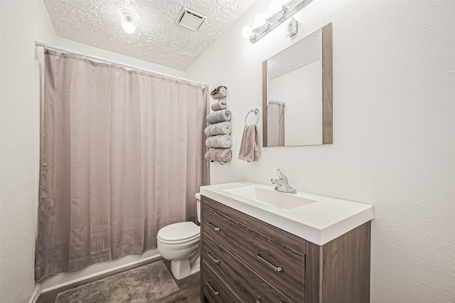 bathroom with toilet, visible vents, a textured ceiling, and vanity