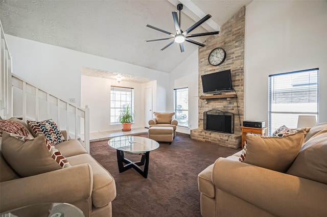 carpeted living area featuring ceiling fan, stairs, a textured ceiling, a fireplace, and high vaulted ceiling