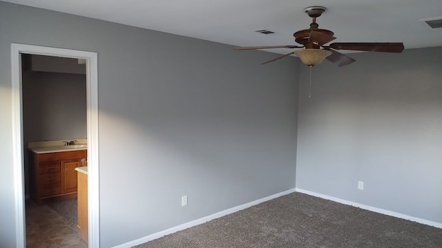 carpeted spare room with a ceiling fan, visible vents, and baseboards