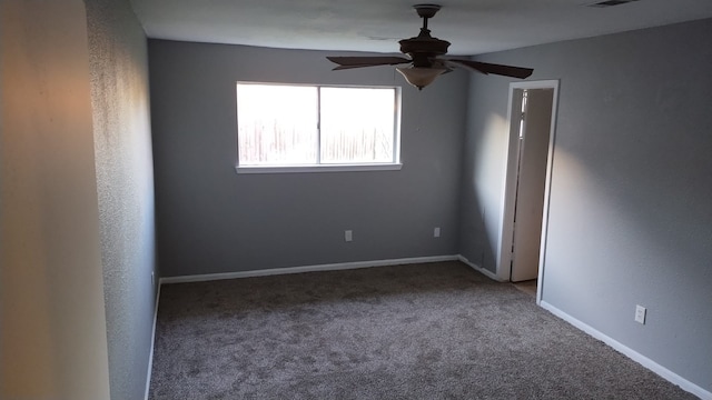 carpeted spare room featuring visible vents, ceiling fan, and baseboards